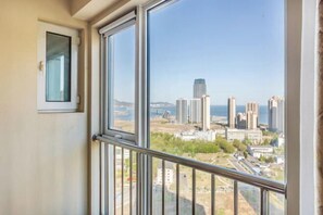 A room with large windows offering a view of a cityscape with high-rise buildings.