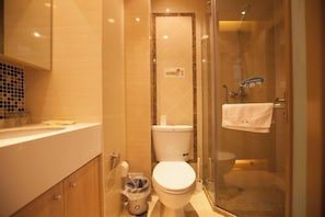 A bathroom with a toilet, a glass shower enclosure, and a sink. - Shanyue Seaview Apartment (Dalian Wanda Plaza Branch) (Dalian)