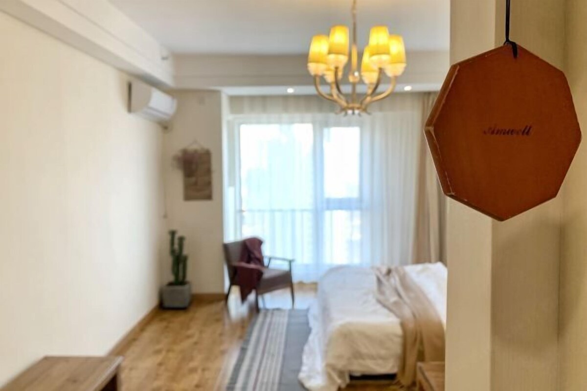 Un dormitorio con cama, una silla, una planta en maceta y una araña.