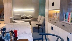 Uma sala de estar moderna com um sofá, uma mesa de centro e uma estante de livros.