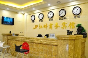 Una recepción con relojes, un televisor y un letrero con caracteres chinos.
