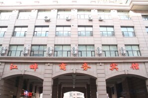A building with multiple floors and large windows. - Jiangpan Business Hostel (Harbin)