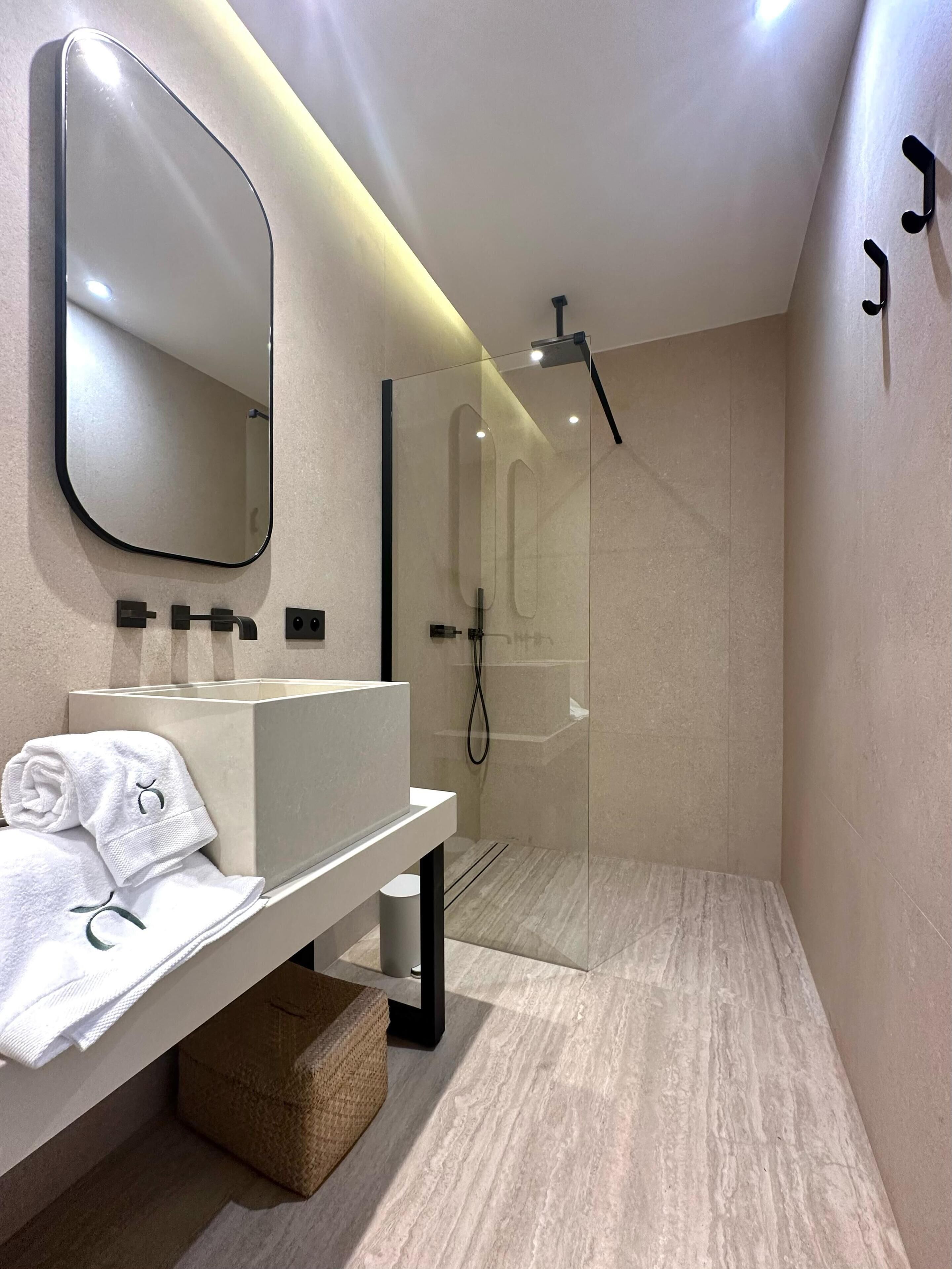 Une salle de bain moderne avec un meuble-lavabo, un grand miroir et une douche à parois de verre.