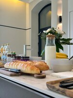 Una encimera de cocina con un pan, un bol y diferentes condimentos.