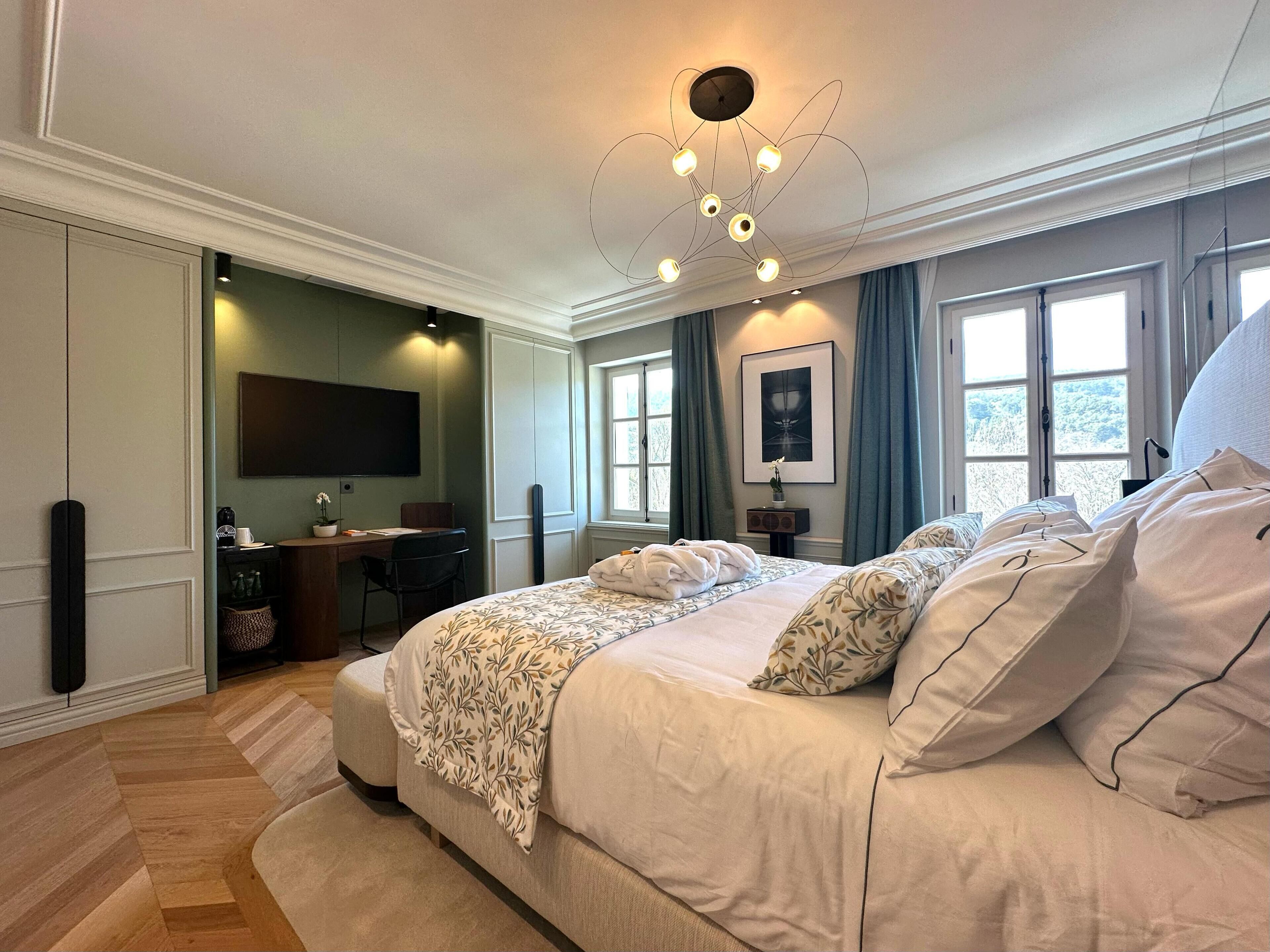 Ein geräumiges Schlafzimmer mit einem großen Bett, einem Schreibtisch und einem Fernseher.