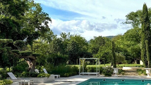 A pool area with a pergola overhead, lounge chairs, and a well-maintained garden. - Chateau Pimo (Draguignan)