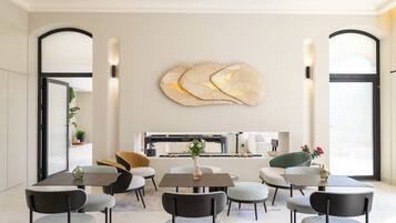 A modern dining area with a central table, surrounding chairs, and a decorative wall piece.