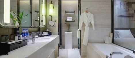 A modern bathroom with a large mirror, a bathtub, a vanity with a sink, and a towel rack.