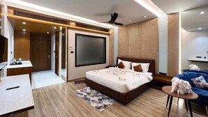 Una habitación de hotel moderna con una cama grande, un escritorio, una silla y un televisor.