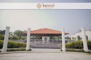 A pavilion with a tiled roof, surrounded by white columns, and a sign reading "banmali palace". - Banmali Palaces  (Titilagarh)