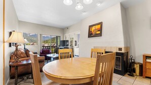 A cozy dining area with a wooden table and chairs, a sofa, and a TV. - Gac316c2 (Copper Mountain)