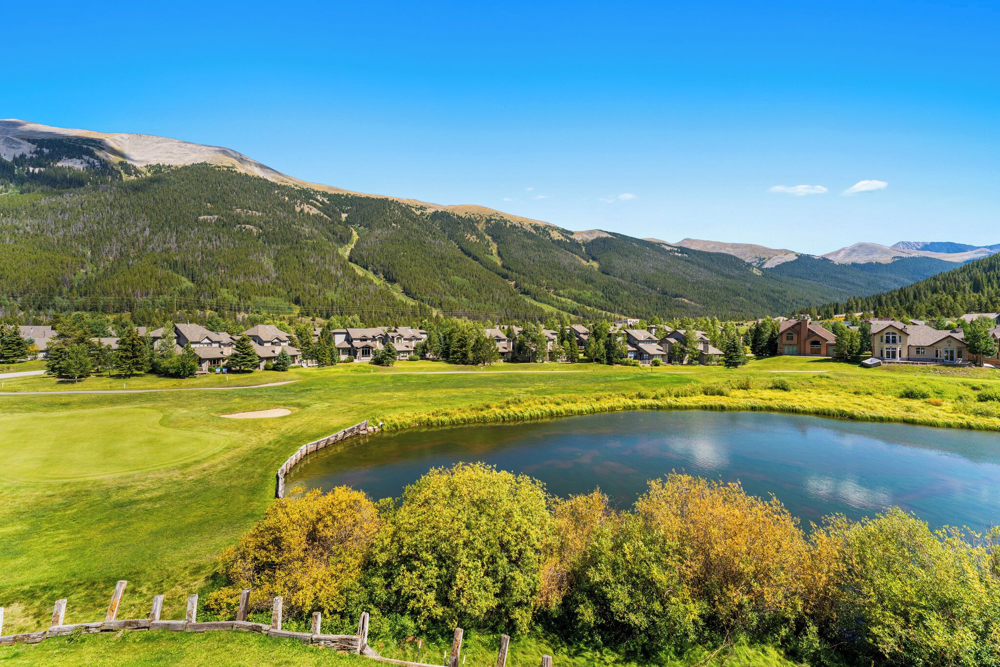 Zona residencial amb cases, camp de golf i un llac.