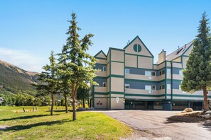 Un edificio de varios pisos con un diseño arquitectónico moderno, que presenta un techo plano y una combinación de formas rectangulares y triangulares.