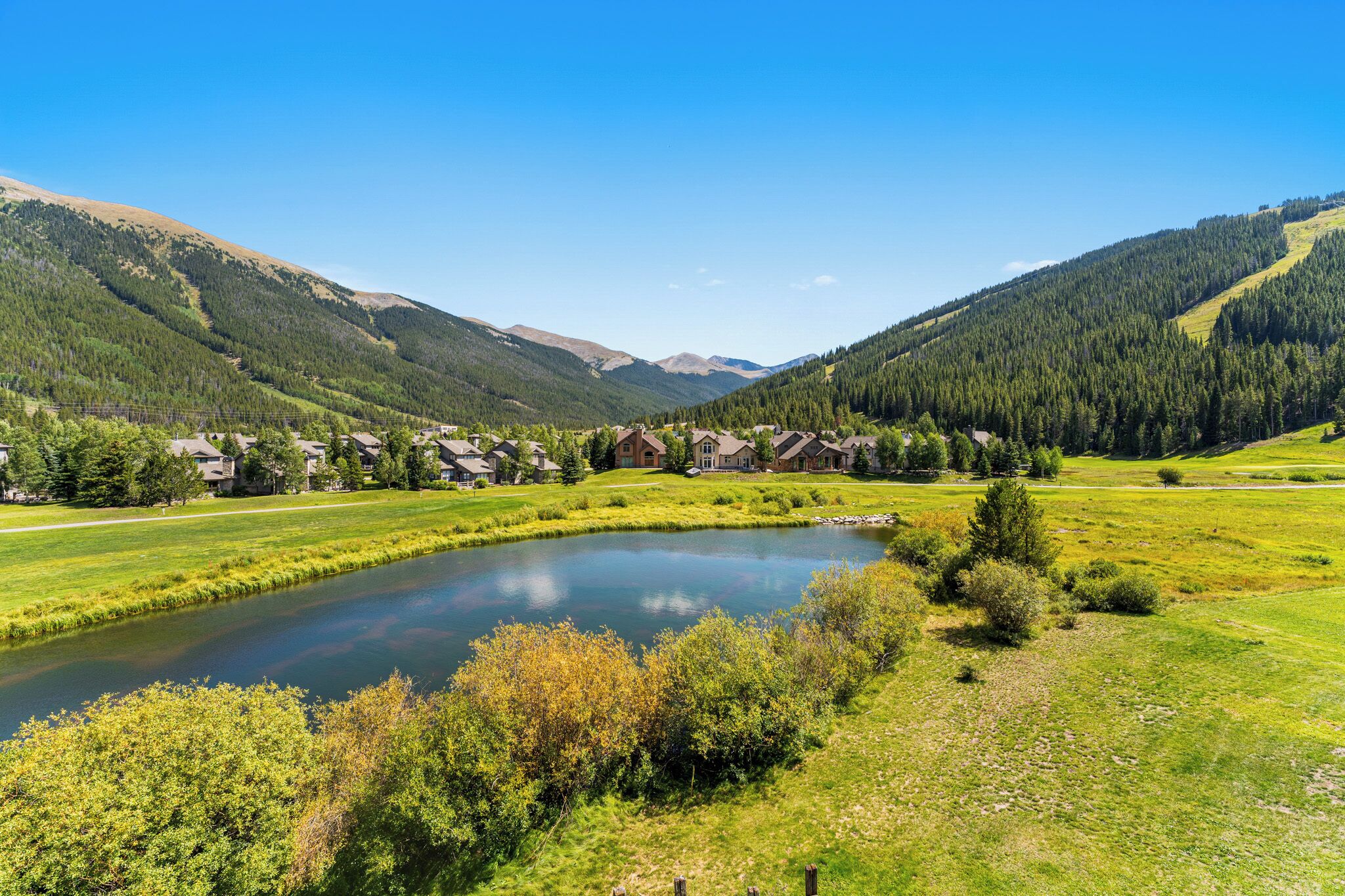 A scenic view of a lake surrounded by lush greenery and mountains.