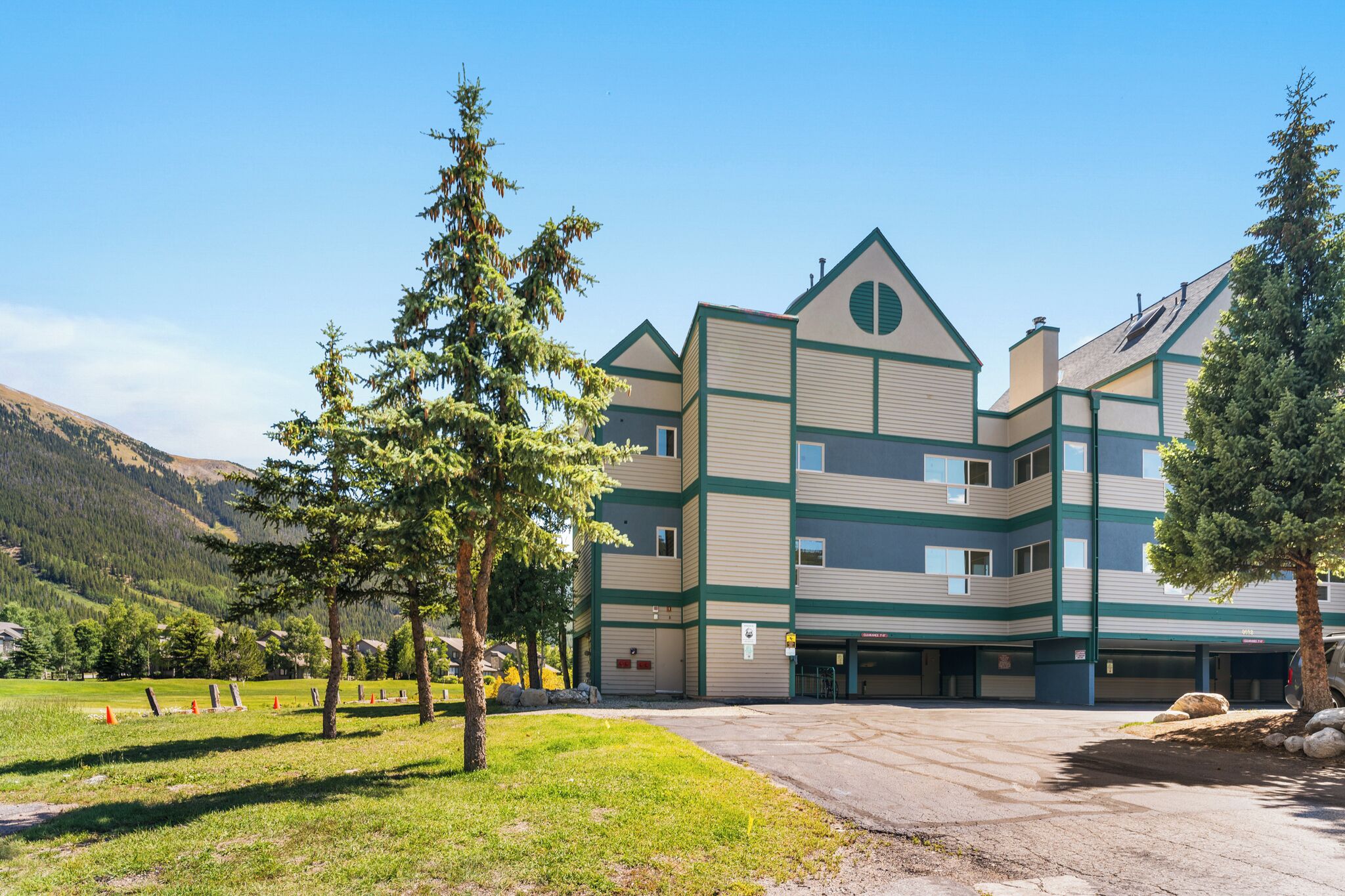 Un edificio de varios pisos con un diseño arquitectónico moderno, que presenta un techo plano y una combinación de formas rectangulares y triangulares.