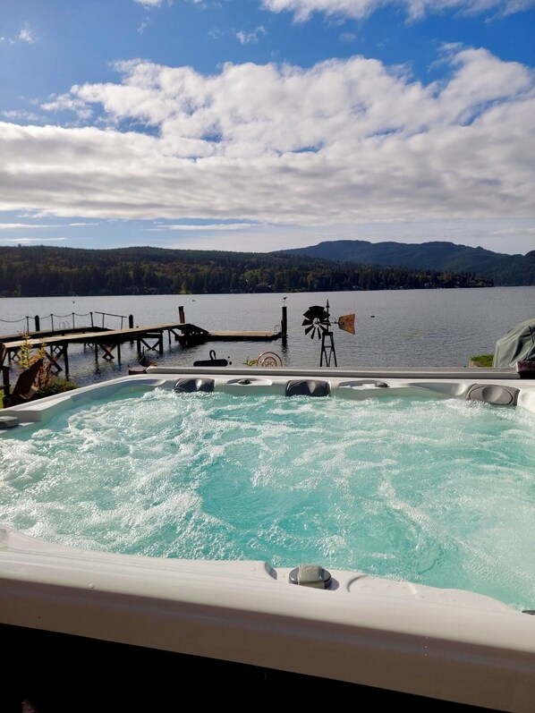A hot tub with a view of a lake and mountains in the background. - Quaint Lakefront Cottage w/Hot tub In Bellingham (Bellingham)
