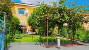 A yellow building with a satellite dish, a garden with a pergola, and a blue fence. - Panoramic in the Hillside surrounded by greenery (Moncalieri)