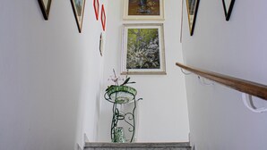 A marble staircase with framed artwork on the walls. - Panoramic in the Hillside surrounded by greenery (Moncalieri)