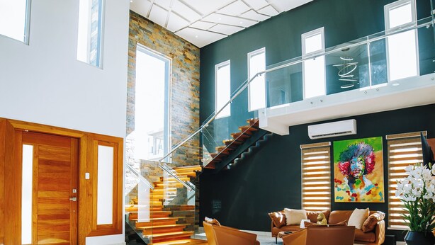 A spacious living area with a staircase, wooden doors, and modern furnishings.
