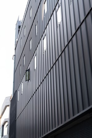 A modern building with a vertical ribbed facade and multiple windows. - HOTEL MYEONGDONGJANG (Seoul)