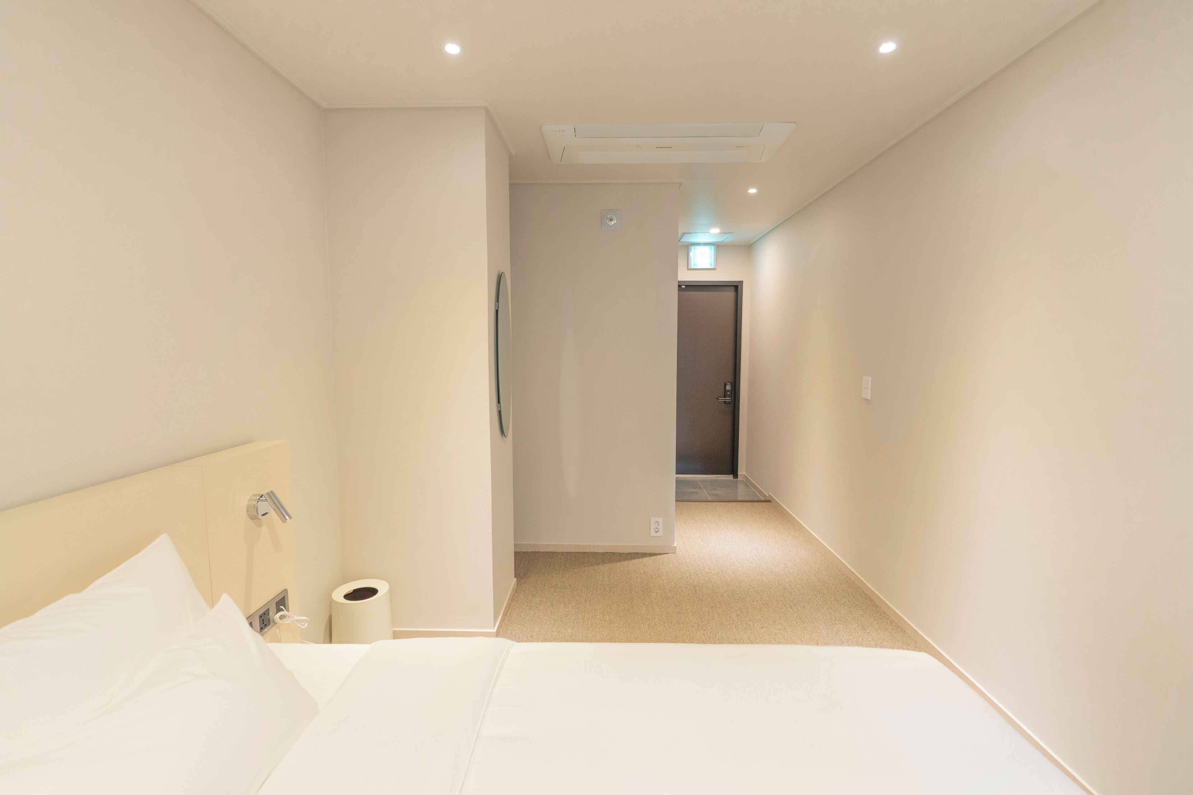 Ein Hotelzimmer mit Bett, Nachttisch, Toilette und Duschbereich.