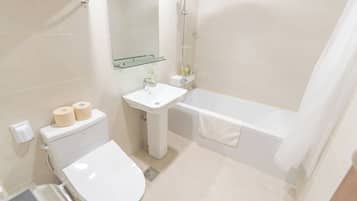 Une salle de bain avec des toilettes, un lavabo et une baignoire.
