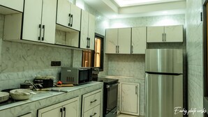 Una cocina moderna con encimeras de mármol, electrodomésticos de acero inoxidable y armarios blancos.