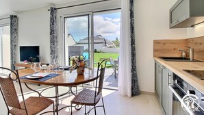 Eine moderne Küche mit Einbauofen, Spüle und Fenster mit Blick auf einen Garten.