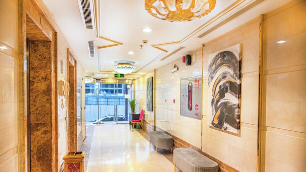 A hotel lobby with marble flooring, a reception desk, a seating area, and a large abstract painting on the wall. - Golden Hospitality Hotel (Makkah)