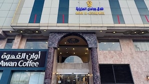 The exterior of the Golden Al-Aziziya Hotel with a prominent entrance and a coffee shop named Awan Coffee. - Golden Hospitality Hotel (Makkah)