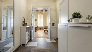 A hallway with a kitchen area, a dining area, and a living room.