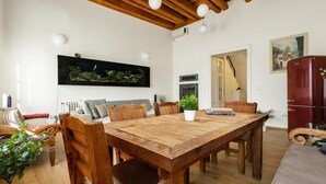 A dining area with a wooden table, chairs, and a potted plant.
