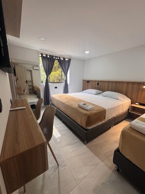 Un dormitorio moderno con una cama grande, un escritorio y una silla.