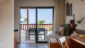 A hotel room with a balcony, a bed, a desk, and a chair. - Arara House (Jijoca de Jericoacoara)
