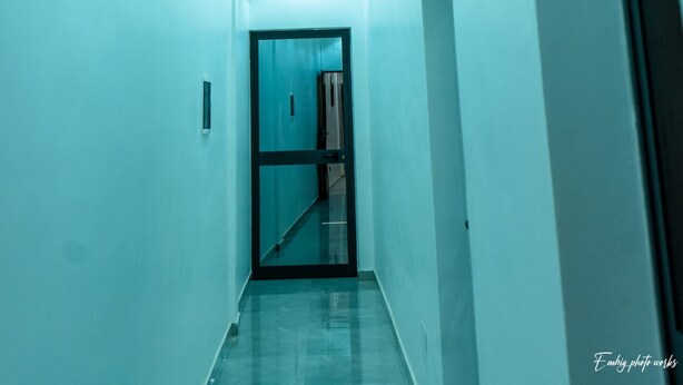 A hallway with a modern design, featuring a straight path and a door at the end.