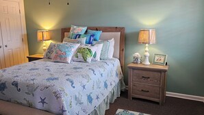 A bedroom with a bed, two nightstands, a wooden door, and a wall with a picture frame. - Beverly hills inn (Aberdeen)