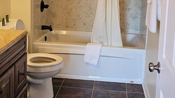 A bathroom with a bathtub, toilet, and vanity.