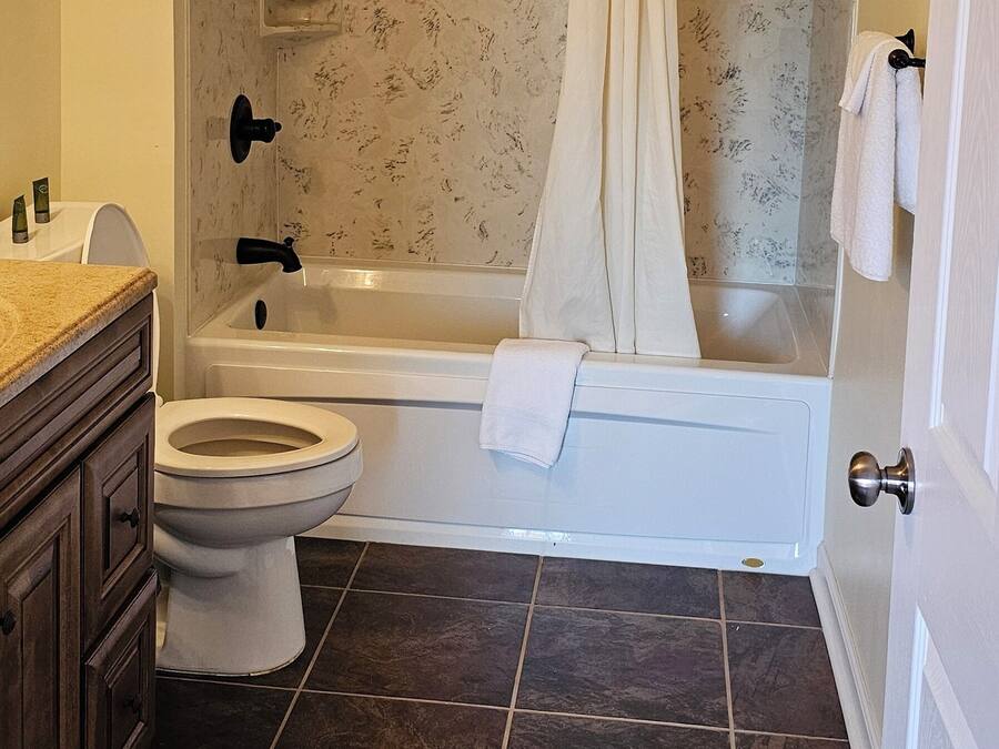 A bathroom with a bathtub, toilet, and vanity.