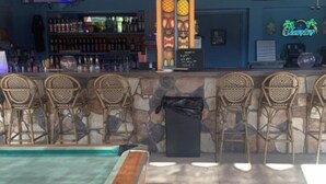 A bar area with a pool table, bar stools, and a variety of drinks on shelves. - Beverly hills inn (Aberdeen)