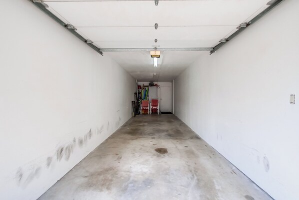 Un garage propre et vide, avec un sol en béton et des murs blancs.