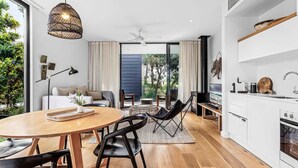 Une cuisine moderne avec un coin repas, un ventilateur de plafond et une vue sur l’extérieur.