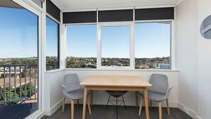 A room with a bay window overlooking a residential area.