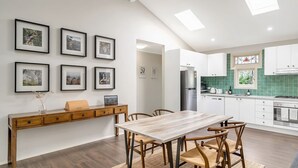 A modern kitchen with white cabinets, a stainless steel refrigerator, and a green backsplash. - Katoomba Cottage Escape Near the Three Sisters (Katoomba)