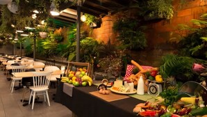 A buffet setup with various fruits and vegetables, a clock, and a table with a red and white checkered tablecloth. - Brick & Beam New York Style Loft in Chippendale (Chippendale)