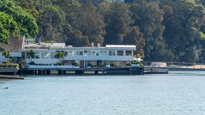 A waterfront property with a long building, multiple decks, and a dock extending into the water. - Pet-Friendly Home Just Minutes from Bondi Beach (Bellevue Hill)