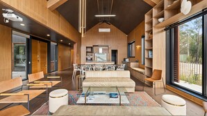 Ein modernes Interieur mit Essbereich, Sofa und großen Fenstern.
