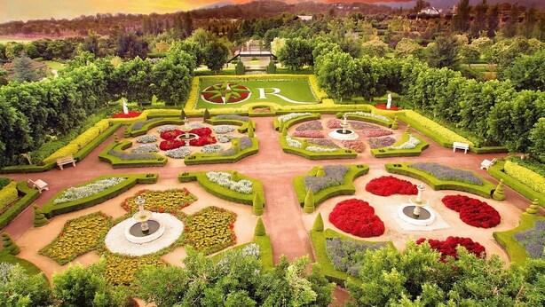 A formal garden with symmetrical design, featuring manicured lawns, flower beds, and statues. - Sip and Soak Up Summer in the Hunter (Cessnock)