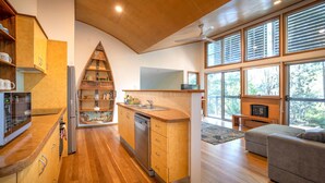 A modern kitchen with wooden cabinets, a built-in oven, and a large window.