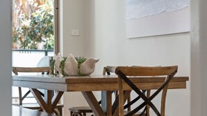 A wooden dining table with two chairs, a white decorative object, and a small plant. - Coastal Retreat in the Heart of Kiama (Kiama)