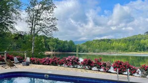 A swimming pool with a view of a lake and trees. - Private Heated Pool! @ The House on the Cove (Hiawassee)